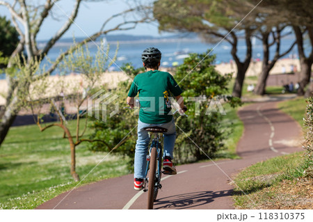 Person riding a bicycle on a cycle path 118310375