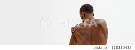 Banner. Rear view of man holding hand on shoulder as he feels pain in joints against white background with negative space. Banner. Rear view of man holding hand on shoulder as he feels pain in joints against white background with negative space. 118310432