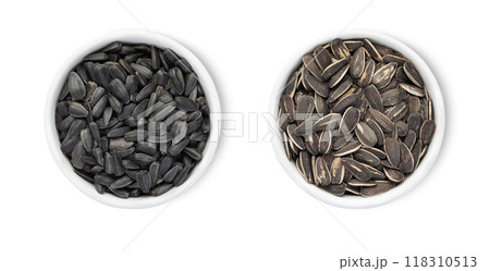 Bowl plates with healthy black sunflower seeds with shell isolated on white background.Top view. 118310513