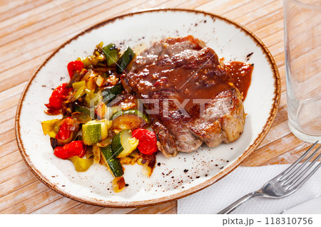 Beef steak with sauce, baked zucchini, bell pepper and onion Beef steak with sauce, baked zucchini, bell pepper and onion 118310756