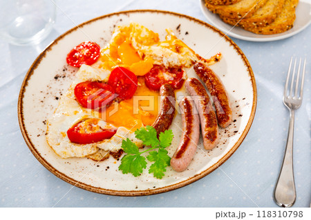 Breakfast with scrambled eggs, sausage and tomatoes 118310798
