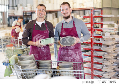 Two men posing with ceramic dishes 118311043