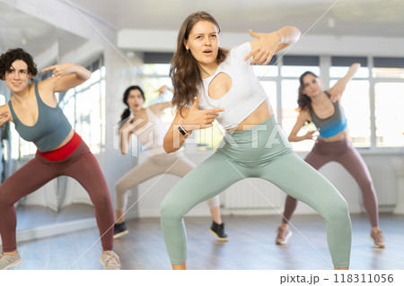 Young female teacher conducts modern hip hop dance lessons for group of girls Young female teacher conducts modern hip hop dance lessons for group of girls 118311056