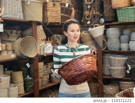Woman choosing a wicker basket at hardware store 118311222