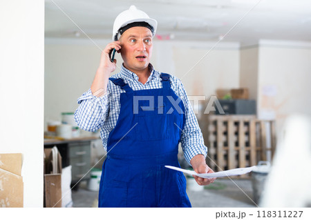 Construction worker having telephone conversation Construction worker having telephone conversation 118311227
