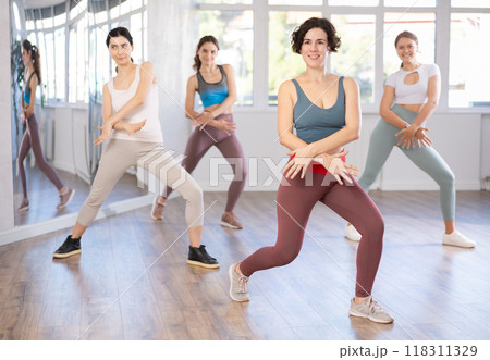 Female teacher conducts modern dance lessons for group of girls 118311329