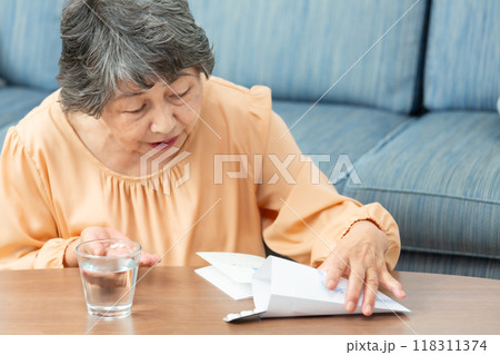 薬を飲むシニア女性 薬を飲むシニア女性 118311374