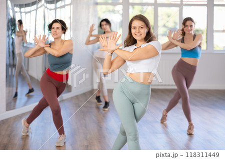 Young female teacher conducts modern hip hop dance lessons for group of girls Young female teacher conducts modern hip hop dance lessons for group of girls 118311449