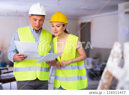 Man and woman builders talking in house 118311457