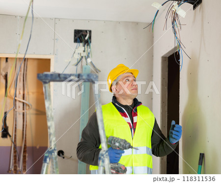 Repair man with drill working in apartmentの写真素材 [118311536] - PIXTA