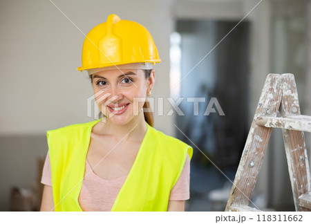 Woman worker posing in apartment being renovated Woman worker posing in apartment being renovated 118311662