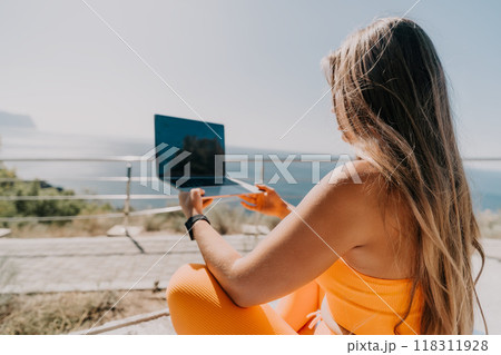 Woman Working on Laptop With Ocean View Woman Working on Laptop With Ocean View 118311928
