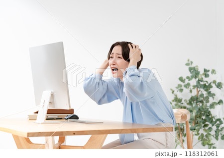パソコンを見て頭を抱える女性 118312061