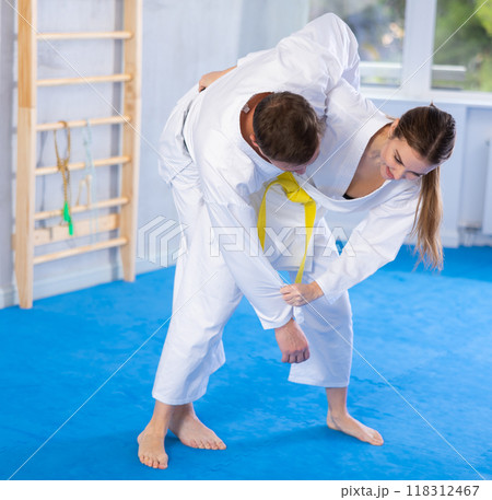 Adult man and young woman training judo fight Adult man and young woman training judo fight 118312467