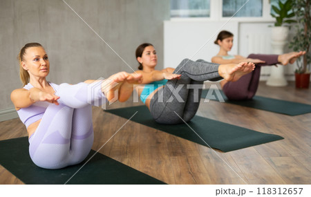 Group of active women practice various yoga poses 118312657