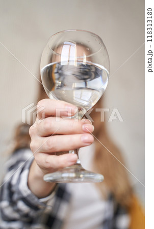 Close-up of woman holding a glass of water with outstretched hand capturing Close-up of woman holding a glass of water with outstretched hand capturing 118313180