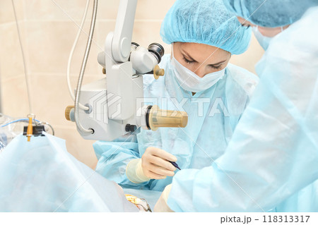 Surgical procedure in hospital operating room with medical staff using advanced 118313317