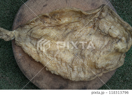 Detail of Fish Maw Soup or Dried Fish Stomach on Old wooden cutting board. Detail of Fish Maw Soup or Dried Fish Stomach on Old wooden cutting board. 118313796