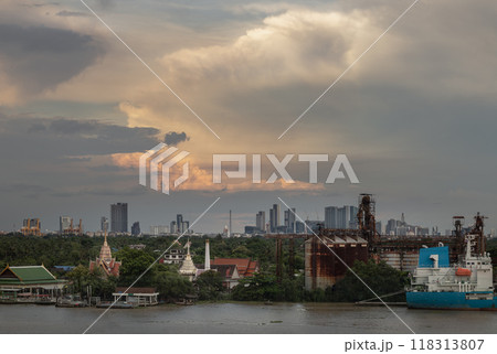 View of green forest area of Bang kachao overlooking Thai temples, Petroleum refinery and cargo ship alongside the Chao Phraya River. 118313807