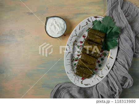 Dolma, cabbage rolls in grape leaves, Traditional Armenian dish, with white sauce, top view, close-up, selective focus, 118313980