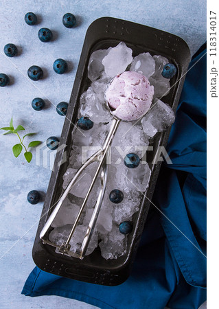 Blueberry ice cream, container with a spoon, on a gray table, fresh blueberries, Blueberry ice cream, container with a spoon, on a gray table, fresh blueberries, 118314017