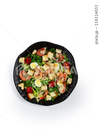 caesar salad with tiger prawns, shrimp salad, lettuce leaves, quail eggs, cherry tomatoes, parmesan cheese, on a black plate, isolate, caesar salad with tiger prawns, shrimp salad, lettuce leaves, quail eggs, cherry tomatoes, parmesan cheese, on a black plate, isolate, 118314031