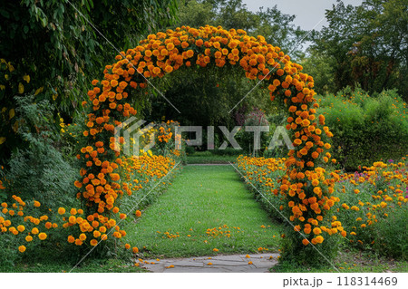 Garden arch covered in orange marigolds, surrounded by lush greenery and flowers 118314469