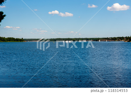Sailboats on water in Sweden. Children sailing small sailboats (catamarans) on a lake. 118314553