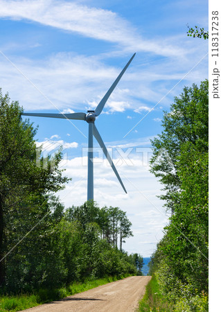 Windmill is producing sustainable energy in the green woodland at the road. Windmill is producing sustainable energy in the green woodland at the road. 118317238