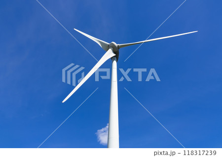 Close-up of a wind turbine on the background of blue sky with a cloud. 118317239