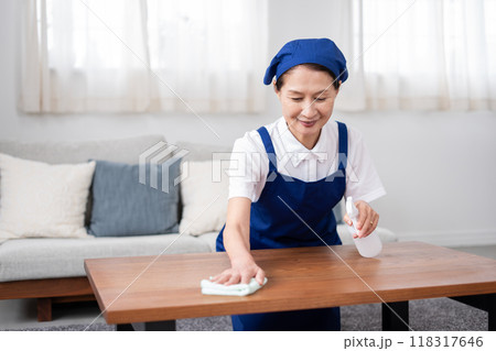 青色のエプロンを付けた白いポロシャツのシニア女性のハウスキーパー 青色のエプロンを付けた白いポロシャツのシニア女性のハウスキーパー 118317646