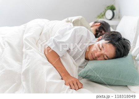 ベッドで眠る若い夫婦（快眠・安眠・熟睡） 118318049