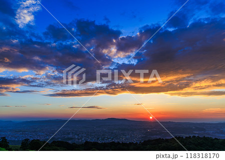 奈良若草山初秋の夕景　生駒山ろくへ沈んで行く夕日と大空の黄金雲②　 118318170