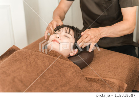ヘッドマッサージ・ヘッドスパ・頭皮マッサージ・スカルプケア・小顔矯正をする女性と整体師・セラピスト 118319387