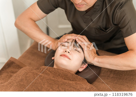 ヘッドマッサージ・ヘッドスパ・頭皮マッサージ・スカルプケア・小顔矯正をする女性と整体師・セラピスト 118319676