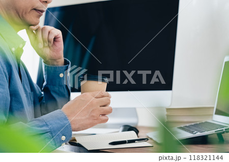 パソコンの前で悩む男性 118321144