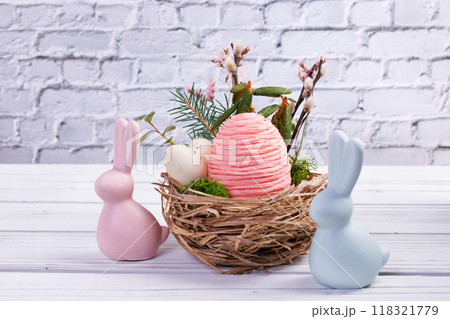 Easter nest with eggs and branches, bunnies on the white table. Easter nest with eggs and branches, bunnies on the white table. 118321779