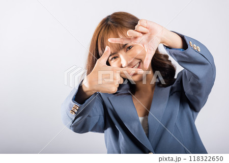 Portrait of a happy young business woman photographer framing with her finger in front of her face, capturing the concept of photography. Studio shot on white background, viewfinder sign 118322650