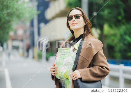 赤ちゃんを抱いて歩く母親　 118322805