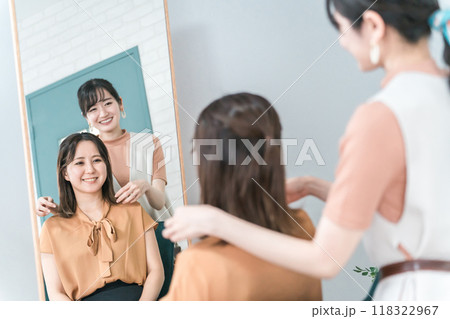 美容室・ヘアサロンで髪型を相談するアジア人女性の客とカウンセリングする美容師・スタイリスト 美容室・ヘアサロンで髪型を相談するアジア人女性の客とカウンセリングする美容師・スタイリスト 118322967