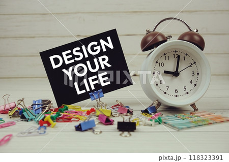 Design Your Life text on paper card with alarm clock and stationary on wooden background 118323391