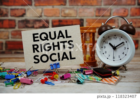 Equal rights social text on paper card with alarm clock and stationary on wooden background Equal rights social text on paper card with alarm clock and stationary on wooden background 118323407