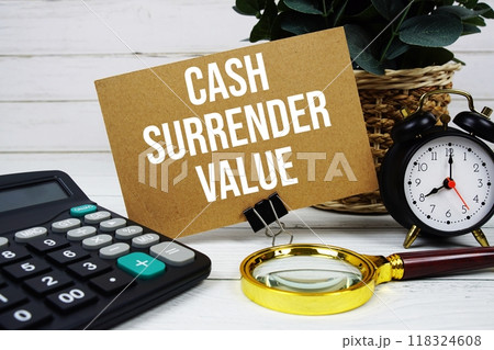 Cash Surrender Value text on paper card with alarm clock, calculator and magnifying glass on wooden background 118324608