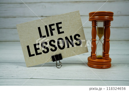 Life Lessons text on paper card with Hourglass on wooden background Life Lessons text on paper card with Hourglass on wooden background 118324656