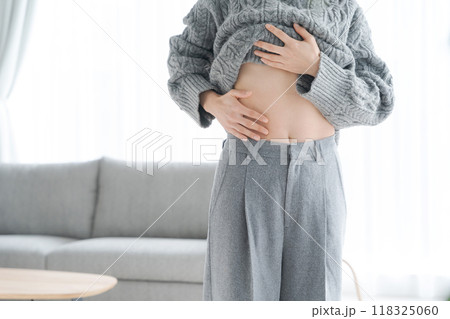 自分のお腹を触る女性 118325060