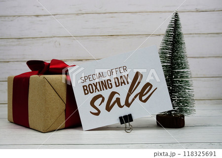 Boxing day Sale text on paper card with gift box and artification pine tree on wooden background 118325691