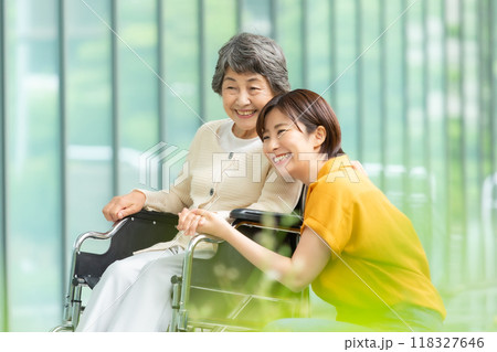 車椅子のシニア女性と介護する若い女性 118327646
