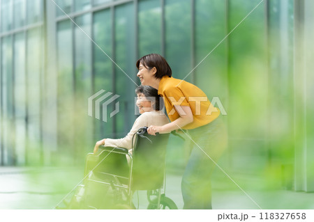 車椅子のシニア女性と介護する若い女性 118327658