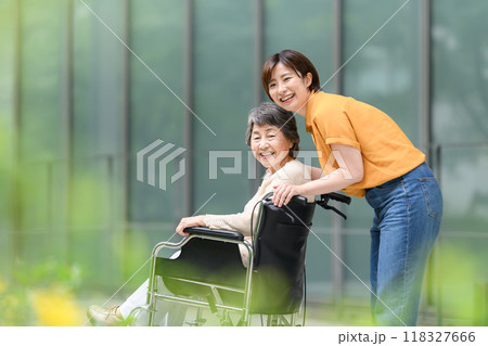 車椅子のシニア女性と介護する若い女性 118327666