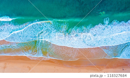 Beautiful ocean beach with yellow sand, aerial view. Drone view of blue waves and sandy beach. Top view - Beautiful Ericeira sandy  beach is famous tourist destination for surfing.  Portugal. 118327684